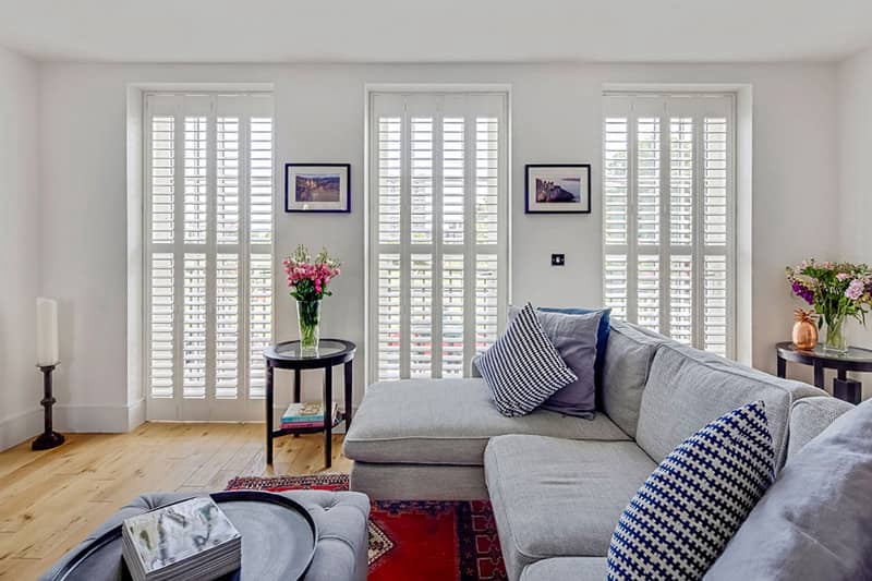 Full height interior shutters installed on a living room window