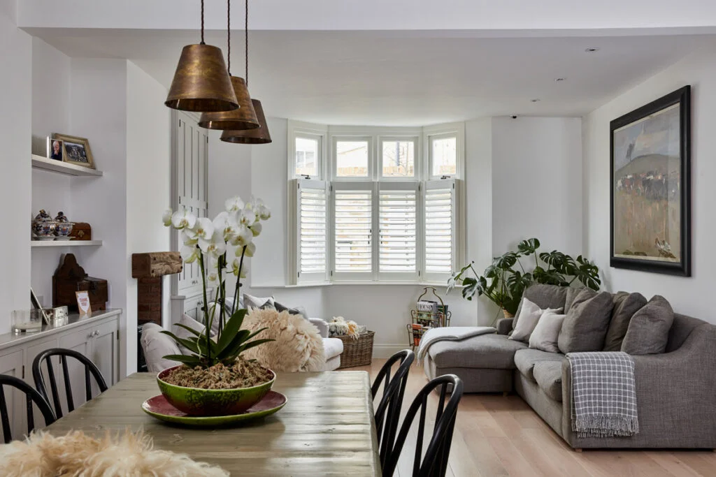 Beautiful living room plantation shutters Hampshire — energy efficient privacy window treatments