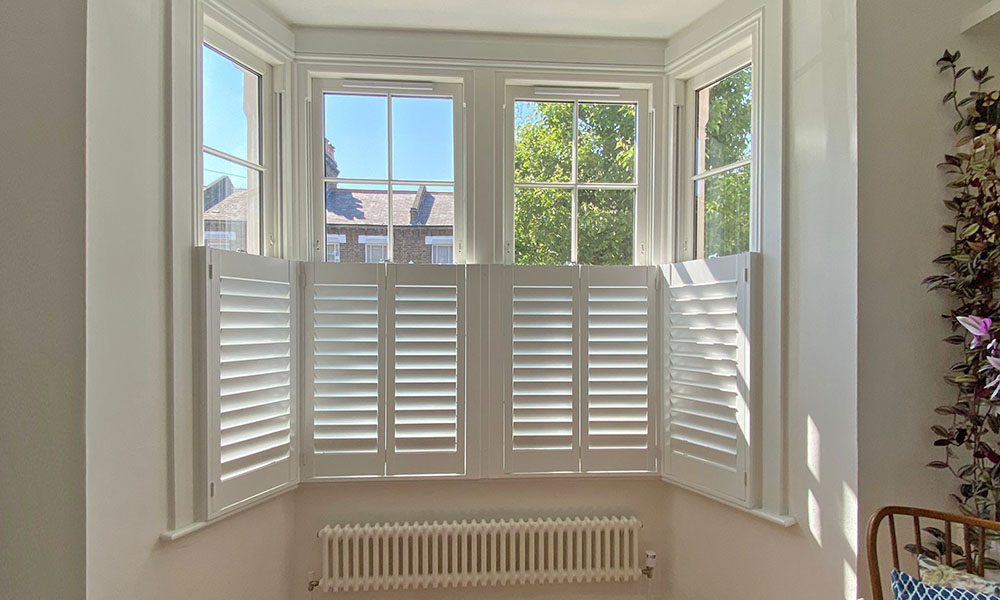 Café style plantation shutters Hampshire large bay window — lower half fitted shutters