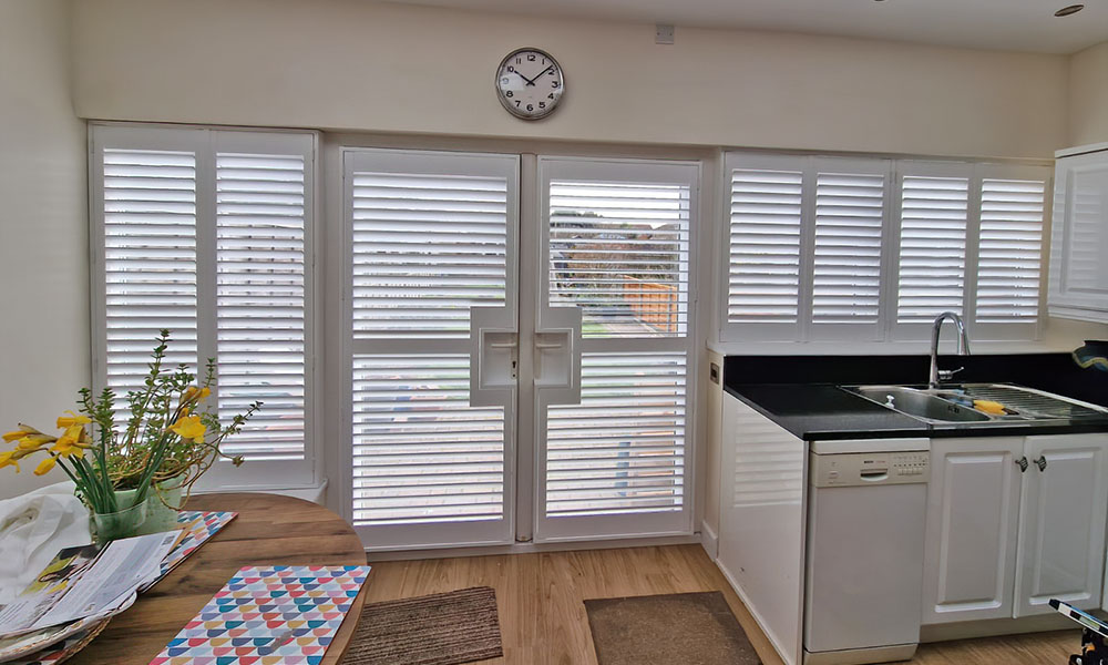 French cut plantation shutters Hampshire kitchen patio doors — Shutters by Balaz