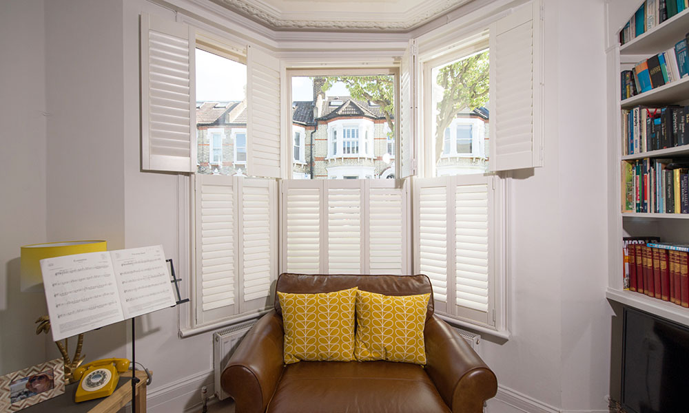 Tier-on-tier plantation shutters Hampshire bay window — independent top bottom control