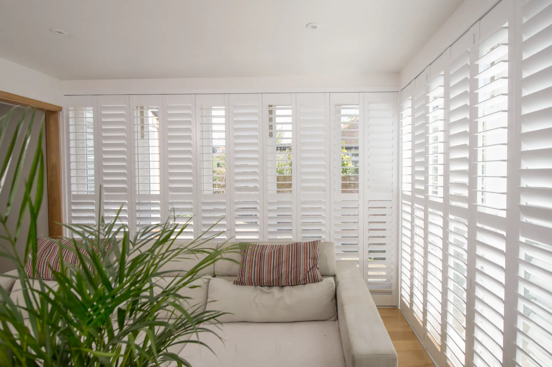 Tracked plantation shutters Hampshire living room — floor to ceiling sliding shutters