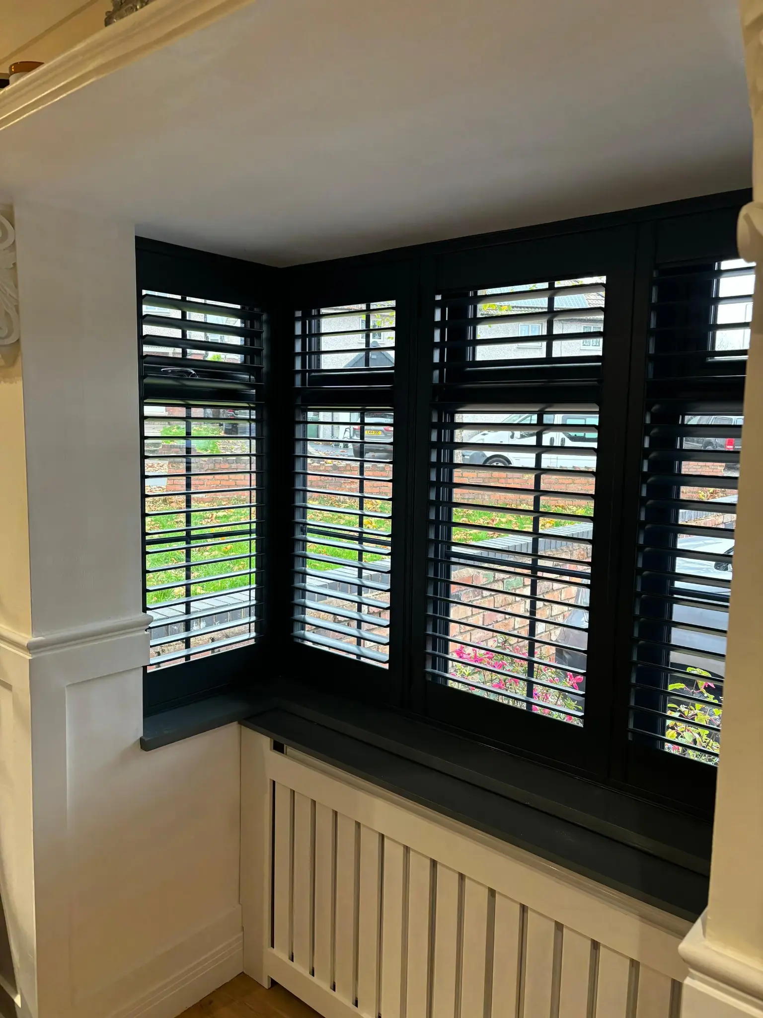 Bay window plantation shutters Hampshire louvres open — light and privacy control